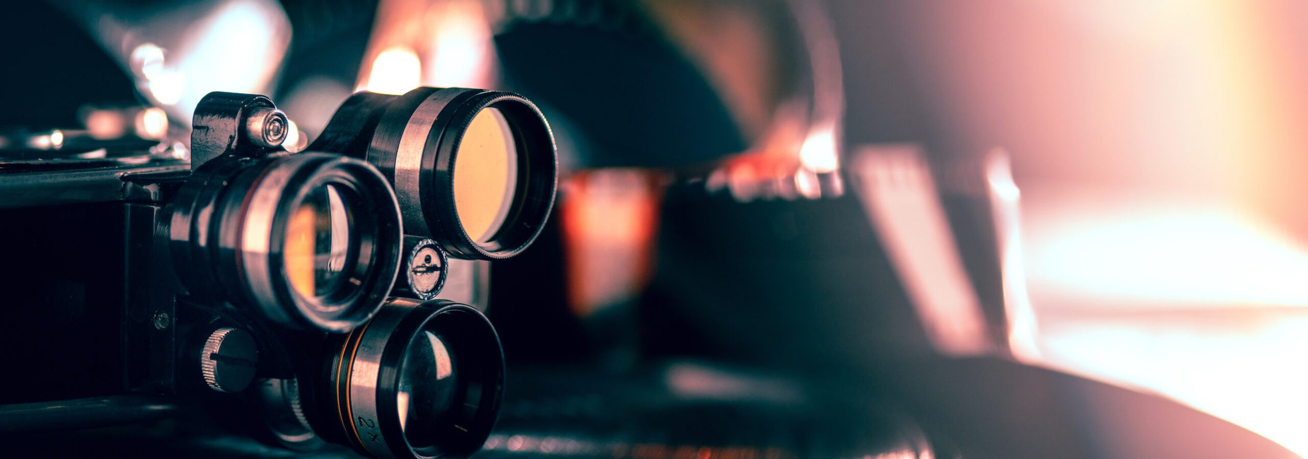 Film projector on dark background. Close up of old retro things shoot with vintage style colors and toned. Flyer for your ad. Concept of retro style, history return, fashioned things, hobby, memories.